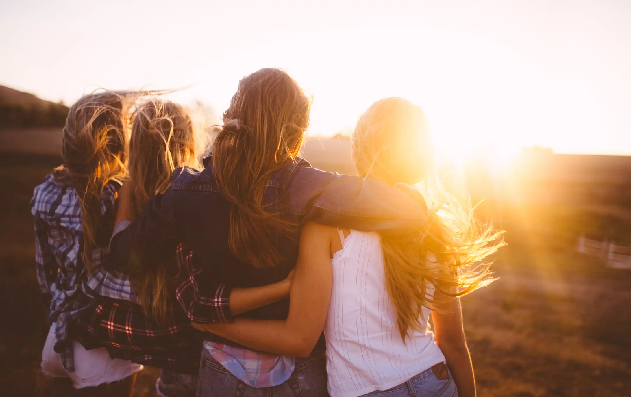 girls in the field looking at the sun